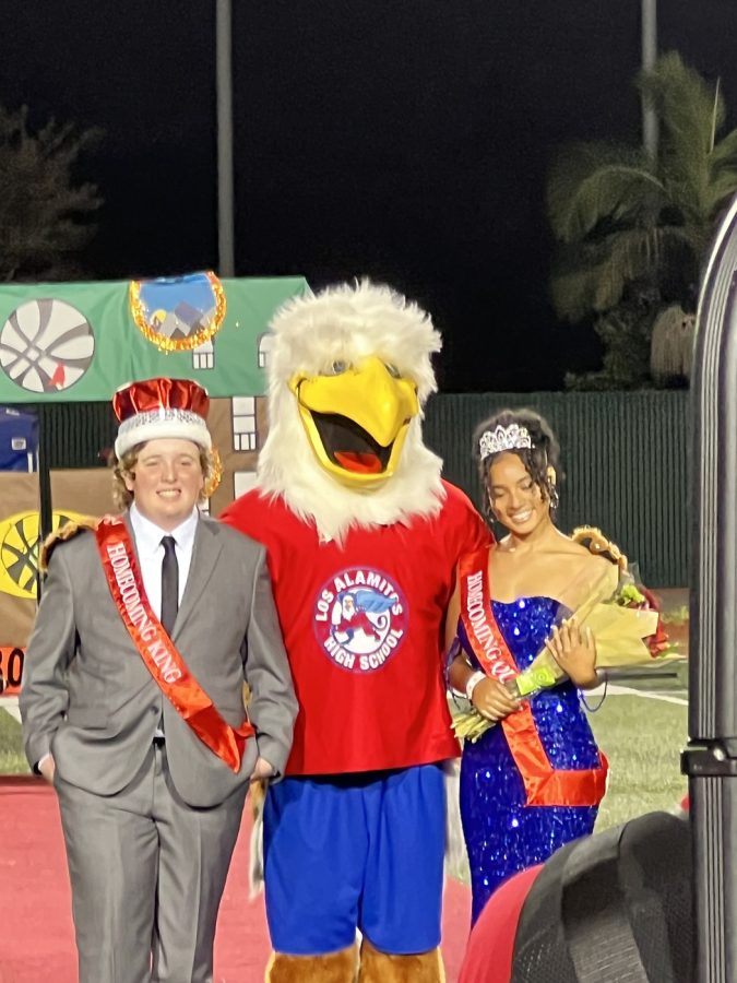 The 2022 Homecoming Queen and King, Lailah Downs and Tyler Small, standing next to the mighty Griffin. 