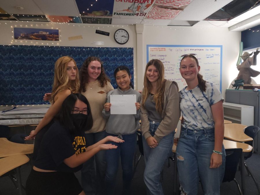 LosAl students holding a Happy Womens History Month! sign. 