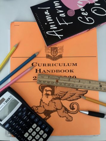 A Los Al curriculum handbook surrounded by various school materials.