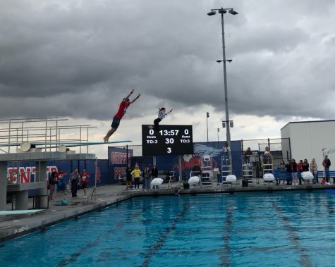 Students jump from the high dive as part of a cannonball competition.