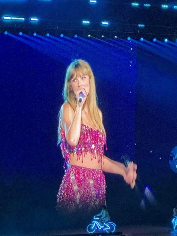Taylor Swift during the eras tour wearing purple, the color most commonly related to speak now.