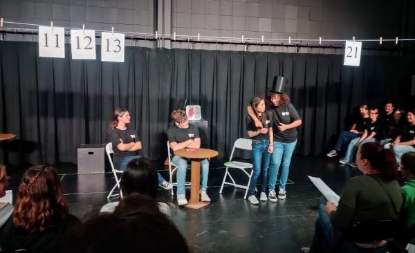 Intermediate Drama students performing The Trade by Sarah Urquiza, where three elementary school kids trade snacks at lunch in the style of a thrilling gameshow.