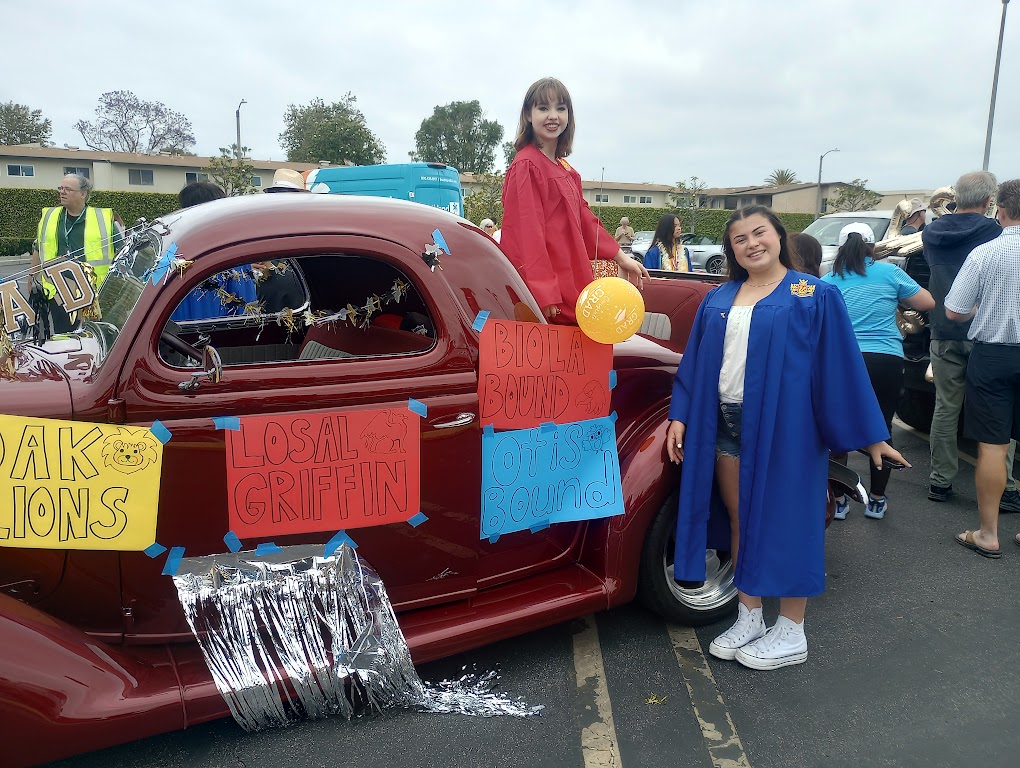 Seniors Ally Braggs and Michaela Ibrahim pose next to their parade vehicle, which is decorated with posters and streamers.