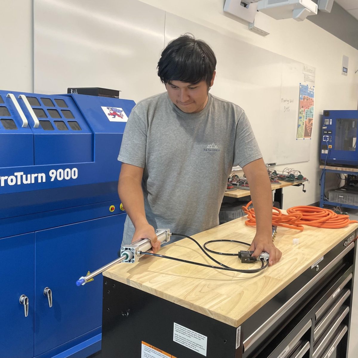 Engineering Society member Bryant demonstrates one of the pneumatics systems.