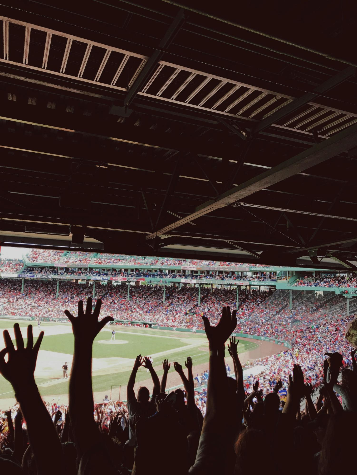 The crack of the bat hitting the ball rings out across the stadium, and the crowd goes wild as they watch the ball soar out of the field. (Photo courtesy of Taylor Rooney, Unsplash)