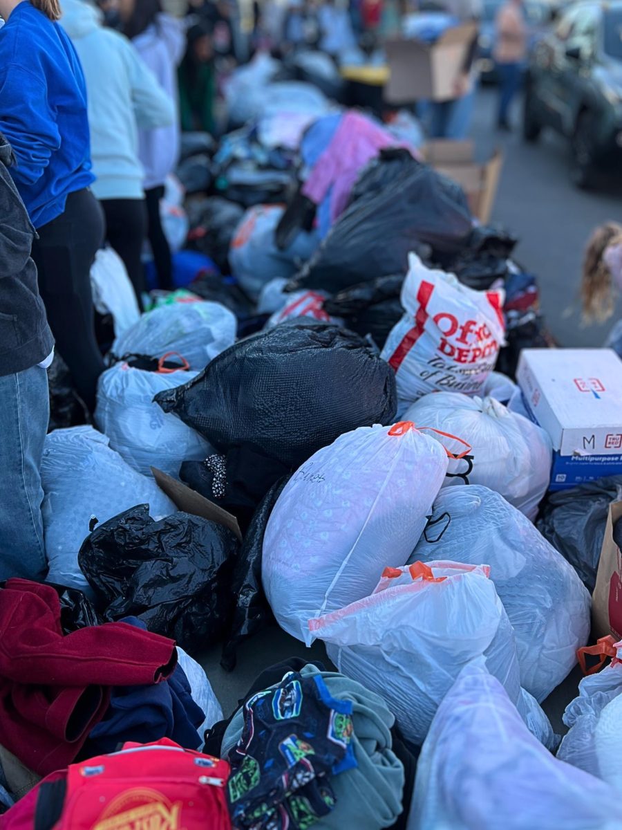 As more and more cars stopped by, the piles of bags and boxes grew; a little over an hour in, volunteers were forced to turn away clothing donations.