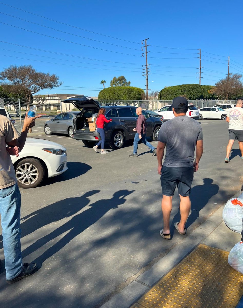 Community members help unload packages into the donation drive area.