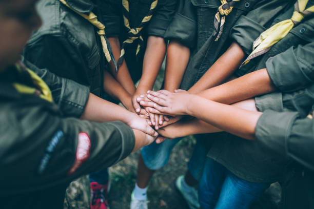 Group of young scouts joining hands together, showing their unity. (Photo courtesy of filmstudio, Unsplash)