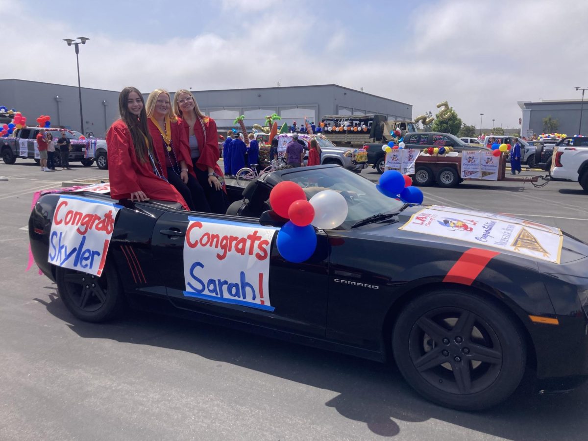 Three LAHS students posed in their decorated Camaro.