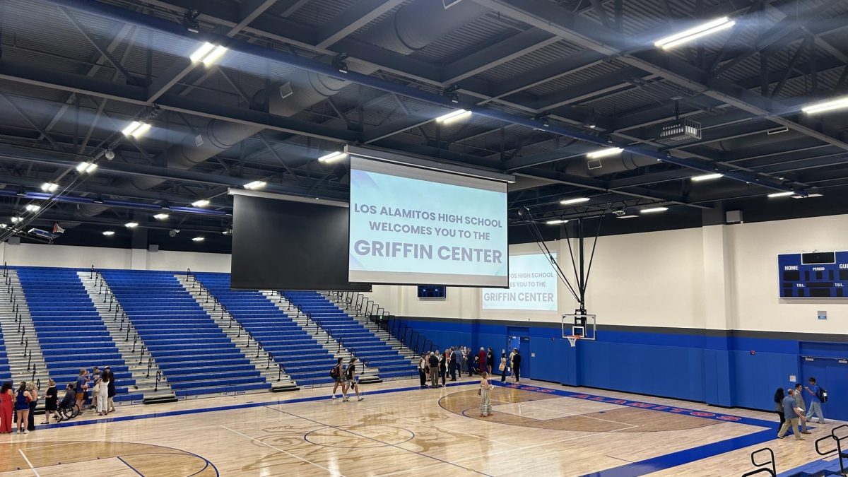 During the open house, drop-down projector screens displayed a welcome message as students and families toured the gym.