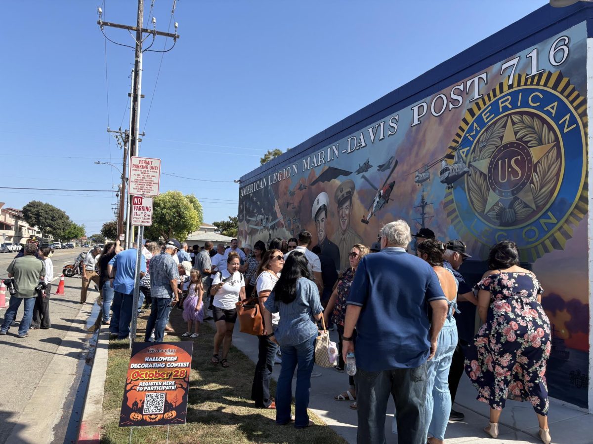 The crowd gathered to appreciate the mural's details and speak with the artist.