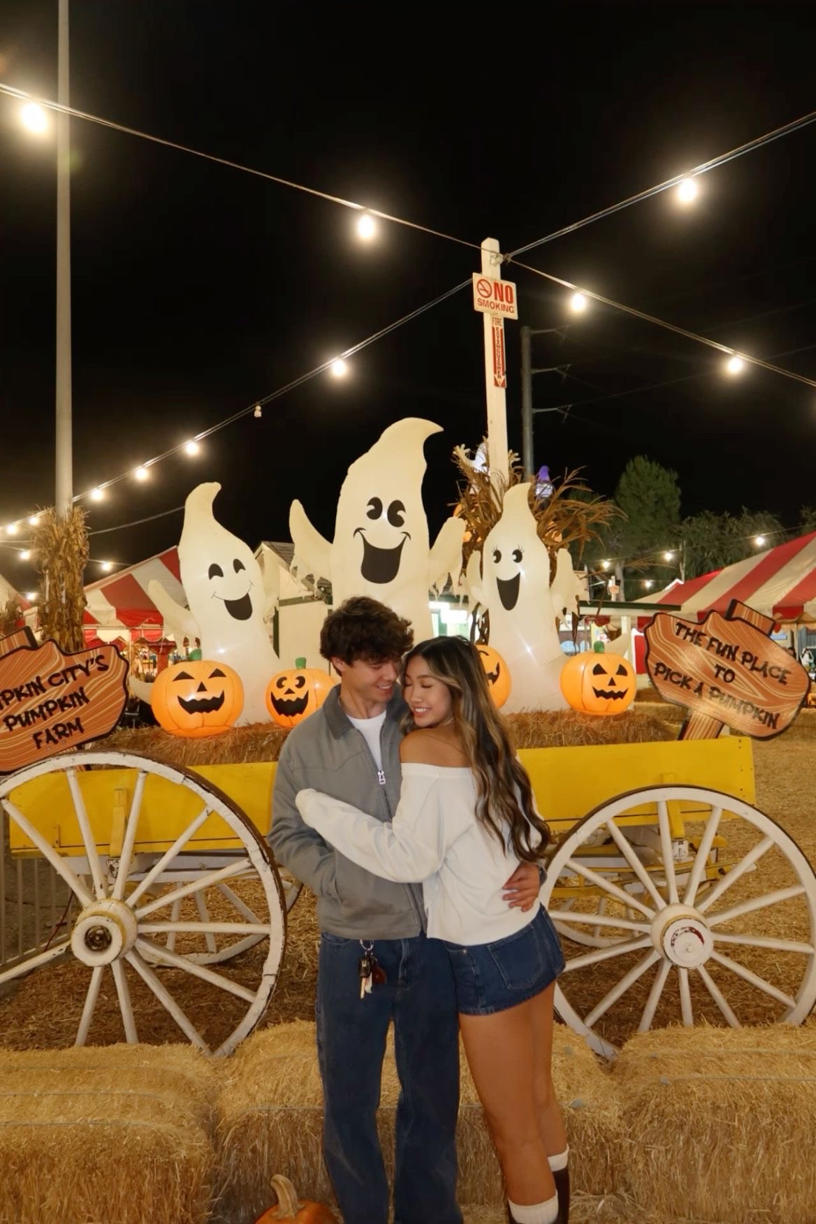 Couple at a pumpkin patch sharing a sweet moment during fall.