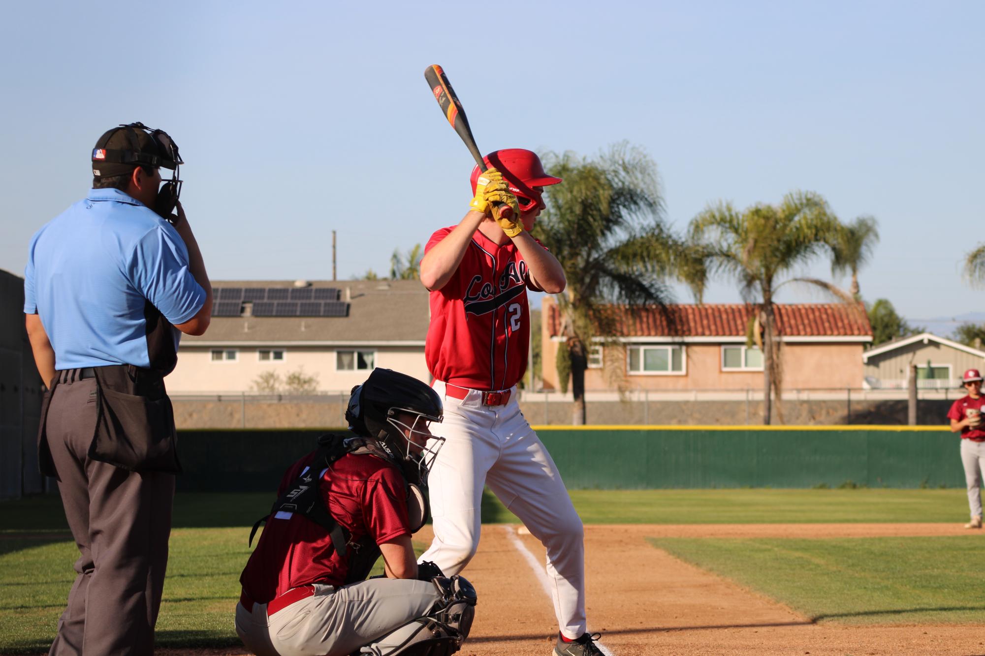 A varsity player batters up to hit in a scrimmage between varsity and junior varsity players.