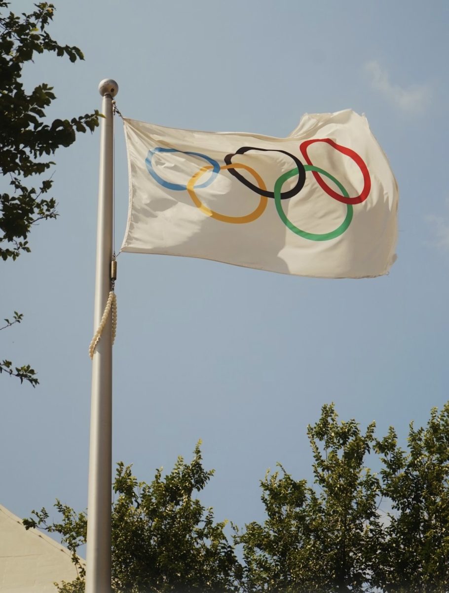The official Olympic flag waving high in the sky as the world prepares for yet another incredible Olympic Games. (Photo courtesy of Unsplash)