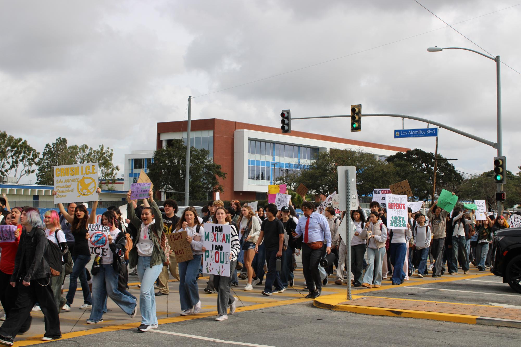 With the LAHS campus and STEM building in the rearview, Griffins walk across Cerritos Avenue on the way to Los Alamitos City Hall as part of the walkout protest from Wednesday. 
