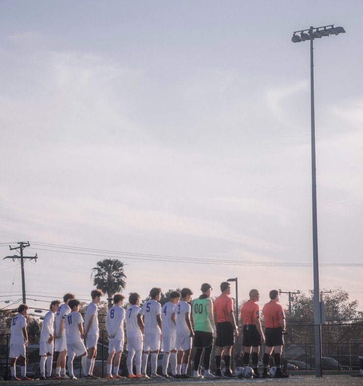 LAHS boys varsity soccer line up on the field before a game (Photo credit via Charles Zahn) 