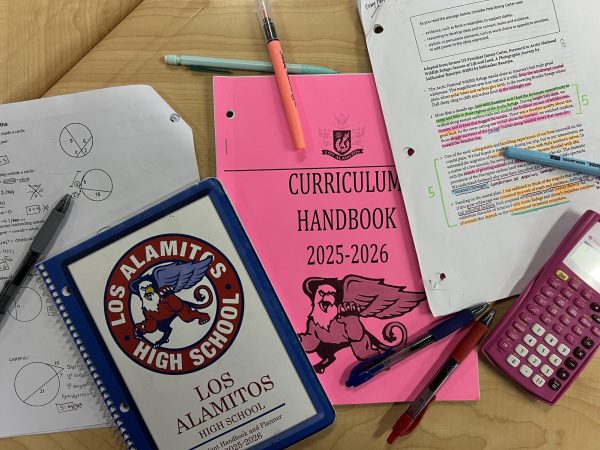 Ninth-grade student materials and work are scattered on a desk in class. 